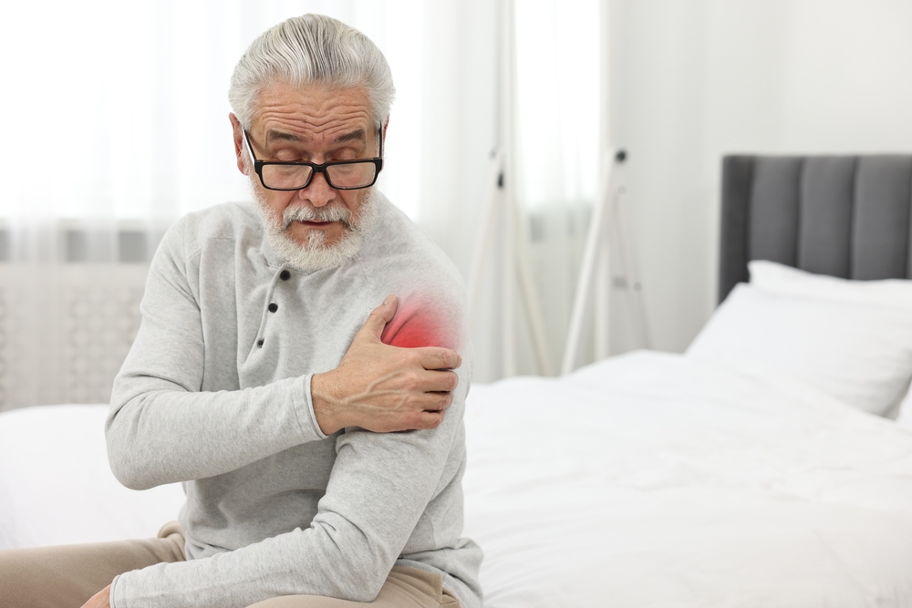 A man is experiencing aching shoulder pain.