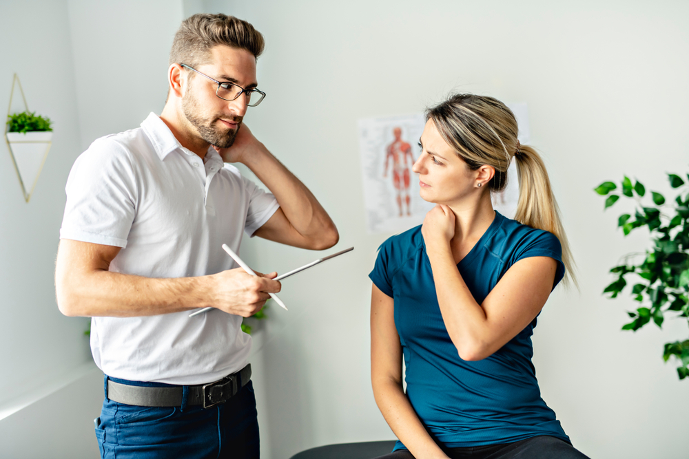 young woman suffering from neck pains visits a physical therapist