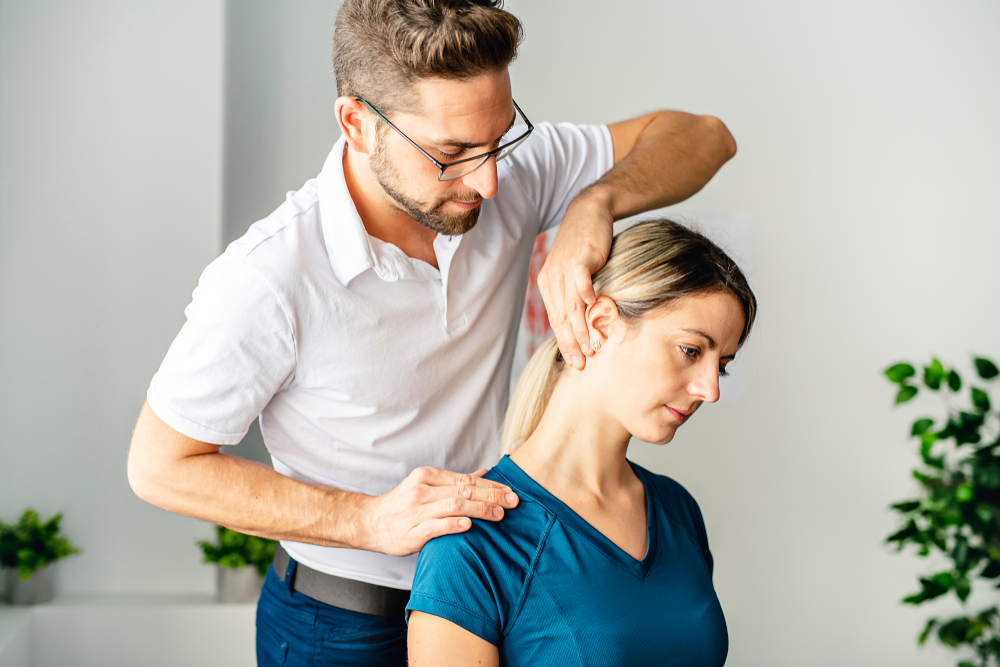 A doctor showing a patient physical therapy techniques for neck pain