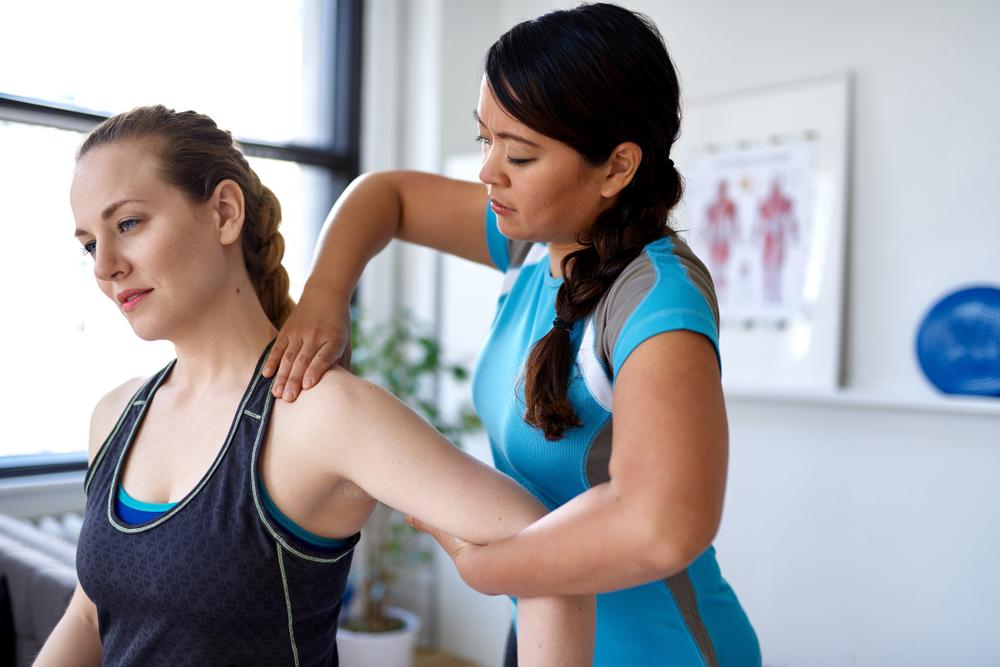 Woman learning about prevention of rotator cuff deterioration from her physical therapist