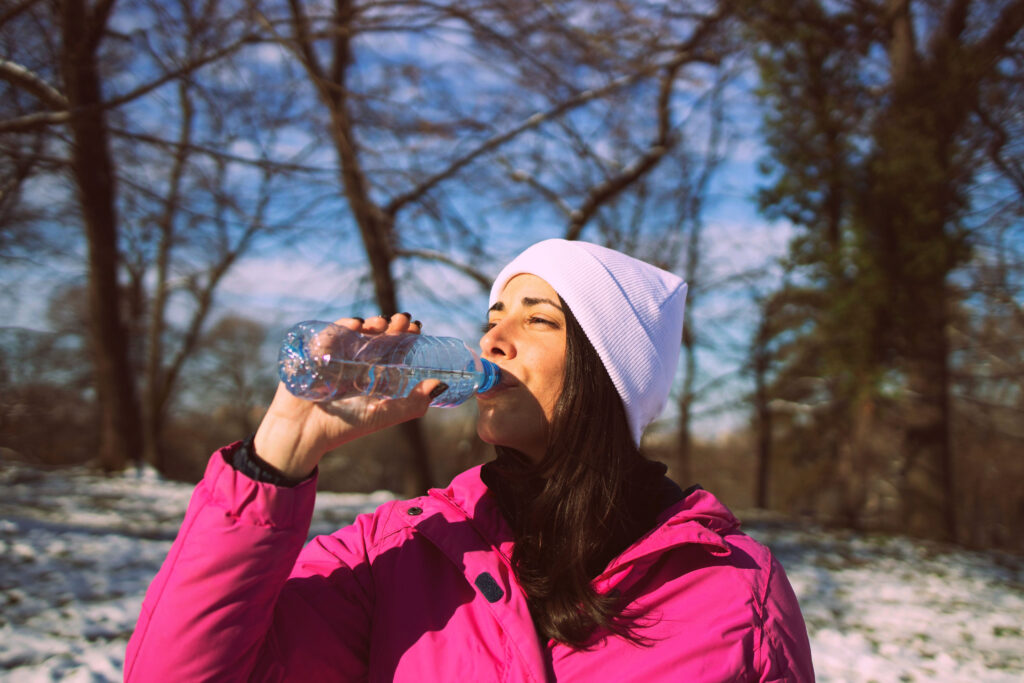 Woman drinking water in the snow