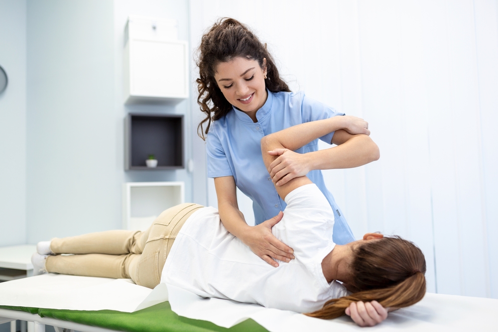 A physical therapist helping a woman achieve chronic pain relief
